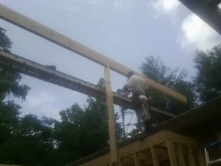 Carpenter setting a ridge beam over a new addition frame — Ice Dam Removal by Roofing Brothers in Centennial