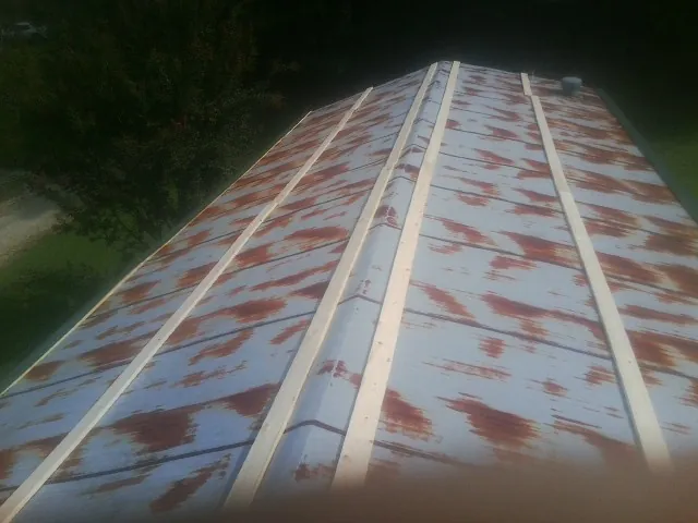 Rusted metal roof panels with new wood purlins before replacement — Storm Damage Roof Repair in Centennial by Roofing Brothers