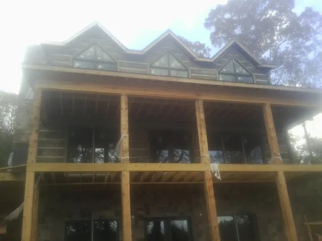 Dormers and porch framing on a large log home under construction — Roof Coating work by our crew in Centennial