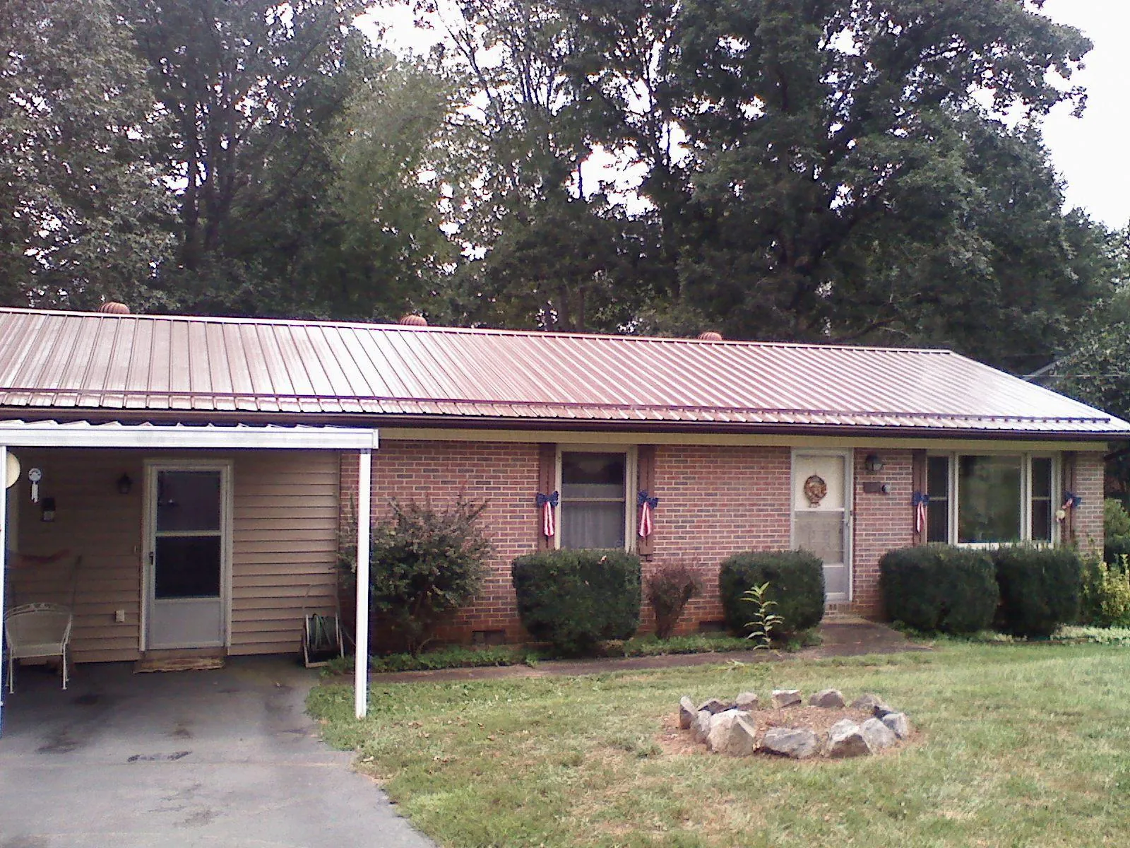 Bronze metal roof and carport on a brick ranch home — Roof Repair work by our crew in Centennial